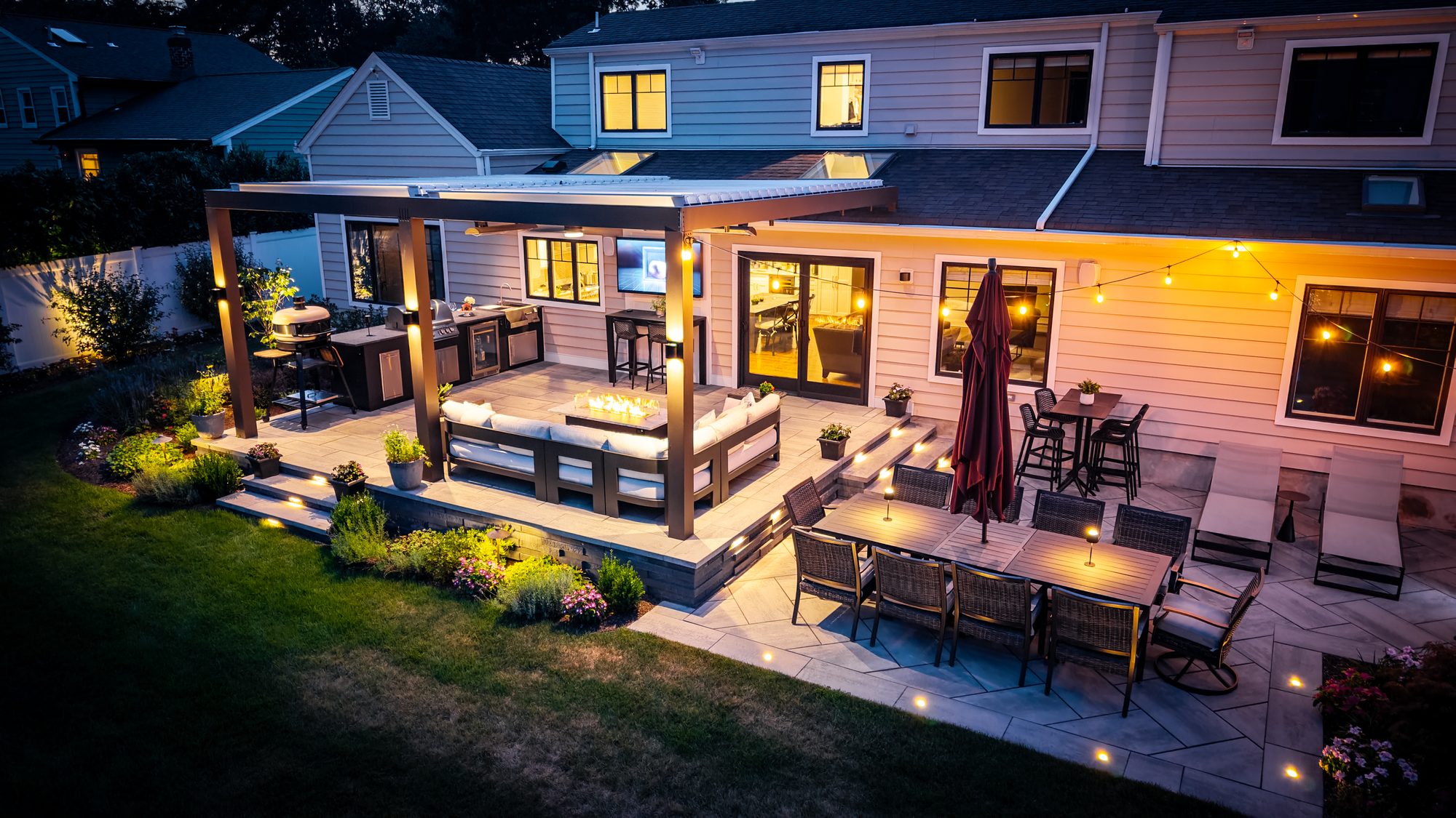 Modern louvered aluminum pergola with built-in lighting over a paver patio